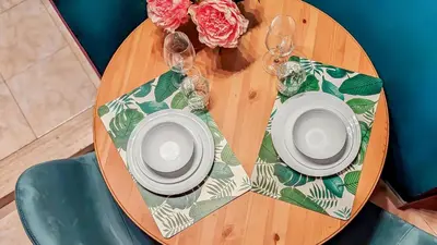 a wooden table with two plates and wine glasses on it at Colosseum Charme Apartments in Rome