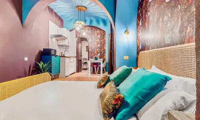 a bedroom with a large bed and a kitchen at Colosseum Charme Apartments in Rome