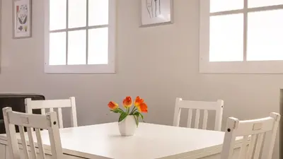 a white dining room table with a vase of flowers on it at Rental in Rome Trastevere White in Rome