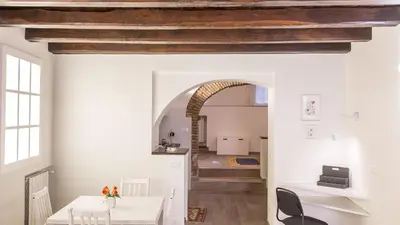 a dining room with a white table and an archway at Rental in Rome Trastevere White in Rome