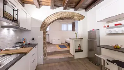 a kitchen with an archway in the middle of a room at Rental in Rome Trastevere White in Rome