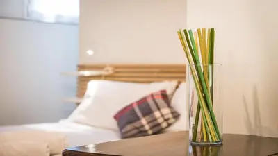 a vase sitting on a table next to a bed at Rental in Rome Trastevere White in Rome
