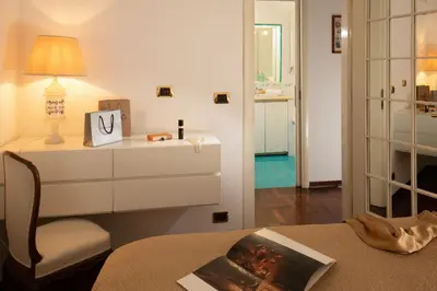 a room with a dresser and a lamp on a table at Riccardo Condotti Suite in Rome