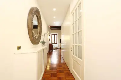 a hallway with a mirror on the wall and a door at Riccardo Condotti Suite in Rome