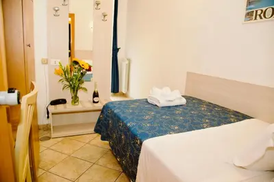 a hotel room with a bed and a vase of flowers at Albergo Marechiaro in Rome