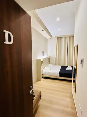 a small room with a bed and a bedroom door at ImeraRooms in Rome