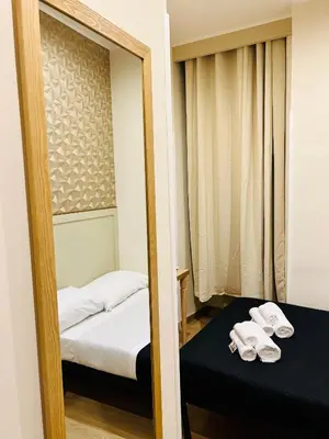 a mirror reflection of a bedroom with a bed and towels at ImeraRooms in Rome
