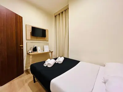 a hotel room with a bed and a television at ImeraRooms in Rome