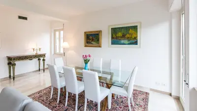 a dining room with a glass table and white chairs at Rental in Rome Colosseo View Luxury in Rome