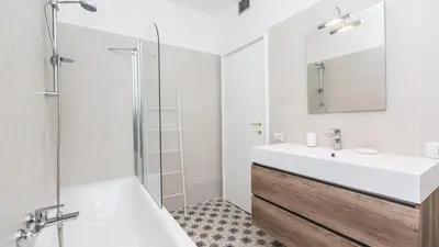 a white bathroom with a sink and a shower at Rental in Rome Colosseo View Luxury in Rome