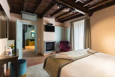 a bedroom with a bed and a chair and a fireplace at Residenza Spada in Rome