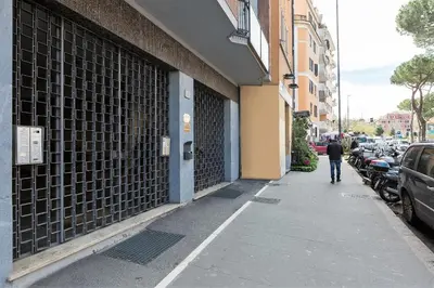 a man walking down a sidewalk next to a building at Dome Terrace Apartment in Rome