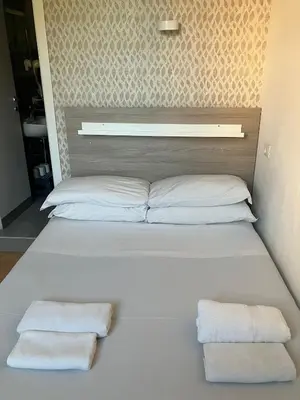a white bed with two towels on top of it at Luciano Laterani Guest House in Rome