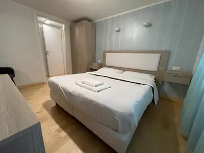 a bedroom with a large white bed with a book on it at Luciano Laterani Guest House in Rome
