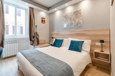 a bedroom with a large bed with blue pillows at Rome Love Hotel in Rome