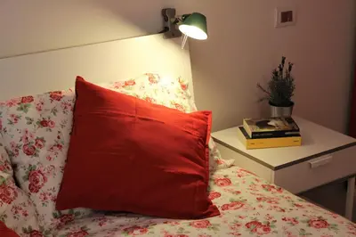 a red pillow sitting on top of a bed at Suite Manzoni in Rome