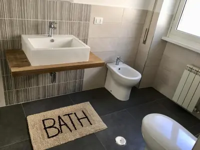 a bathroom with a sink and a toilet and a bath rug at B&B CultRoma Roof Garden in Rome