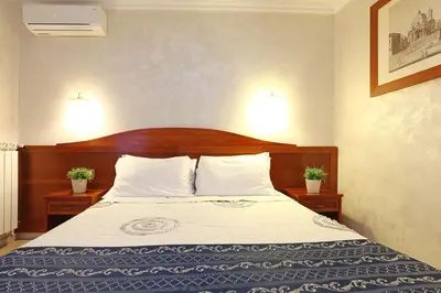 a bedroom with a bed with a wooden headboard at Adorasuite B&B in Rome