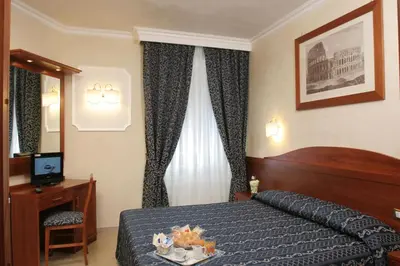 a hotel room with a bed and a table and a television at Adorasuite B&B in Rome