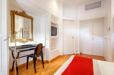 a bedroom with a desk and a mirror and a bed at HT N°9 Colosseo in Rome