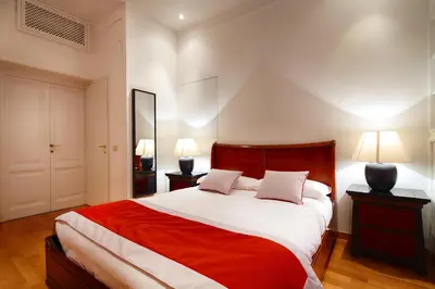 a bedroom with a red and white bed with two lamps at HT N°9 Colosseo in Rome