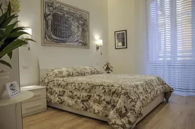 a bedroom with a bed with a comforter and a window at Roma Vespahouse in Rome