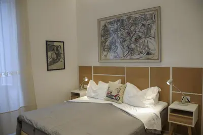 a bedroom with a bed and a painting on the wall at Roma Vespahouse in Rome