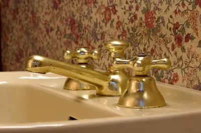 a brass bathroom sink with two faucets on it at Apartment Margutta Center in Rome