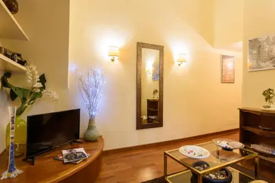 a living room with a table and a mirror at Apartment Margutta Center in Rome