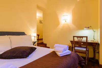 a bedroom with a bed and a desk and a lamp at Apartment Margutta Center in Rome
