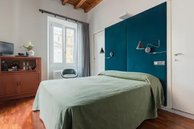a bedroom with a bed with a blue wall at Buonanotte Colosseo in Rome