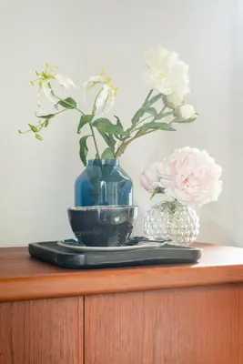 a table with a blue vase and a plate with flowers at Buonanotte Colosseo in Rome