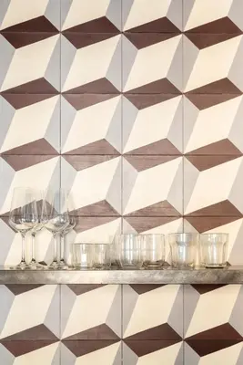a patterned wall in a restaurant with glasses on a shelf at Buonanotte Colosseo in Rome