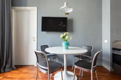 a dining room with a white table and chairs at Buonanotte Colosseo in Rome