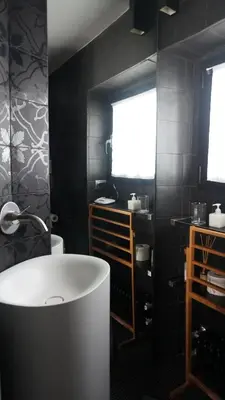 a bathroom with a white tub and black walls at Buonanotte Colosseo in Rome