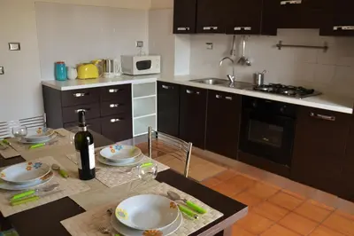 a kitchen with a table with plates and a bottle of wine at Family`s Apartment Trastevere in Rome