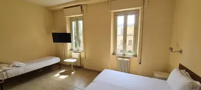 a room with two beds and a tv and two windows at Villa Riari Garden in Rome
