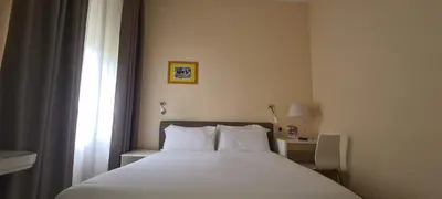 a bedroom with a white bed and a window at Villa Riari Garden in Rome