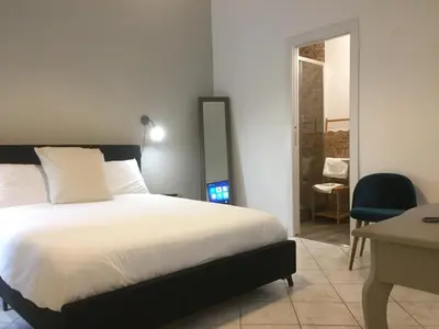 a bedroom with a bed and a desk and a chair at SmooRoomS Roma Ostiense in Rome