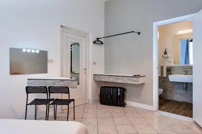 a bathroom with two chairs and a counter and a sink at SmooRoomS Roma Ostiense in Rome