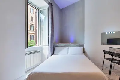 a small bedroom with a bed and a window at SmooRoomS Roma Ostiense in Rome