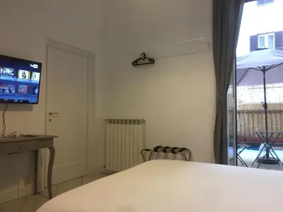 a room with a table and a tv and a window at SmooRoomS Roma Ostiense in Rome