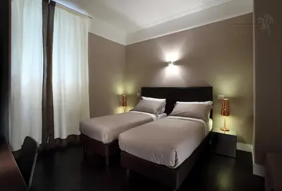 a hotel room with two beds with white pillows at Residence Regola in Rome