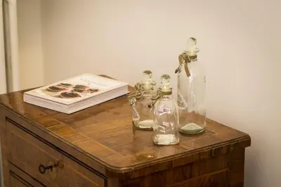 a table with two glass bottles and a book at Prestigious Apartment via Barberini in Rome