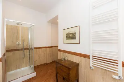 a bathroom with a shower and a wooden table at Prestigious Apartment via Barberini in Rome