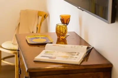 a table with a book and a glass on it at Prestigious Apartment via Barberini in Rome