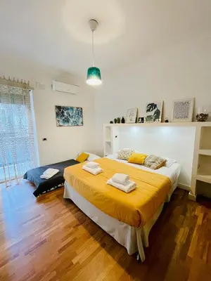 a bedroom with a large bed with a yellow blanket at Be Rome in Rome