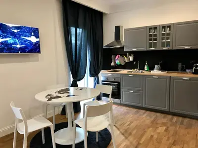 a kitchen with a white table and chairs and a table and a kitchen at Be Rome in Rome