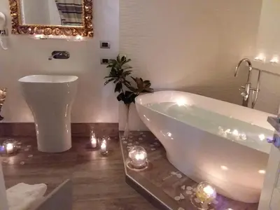 a bathroom with a tub and a mirror and lights at I Fiumi Di Navona in Rome