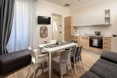 a kitchen and living room with a table and chairs at I Fiumi Di Navona in Rome